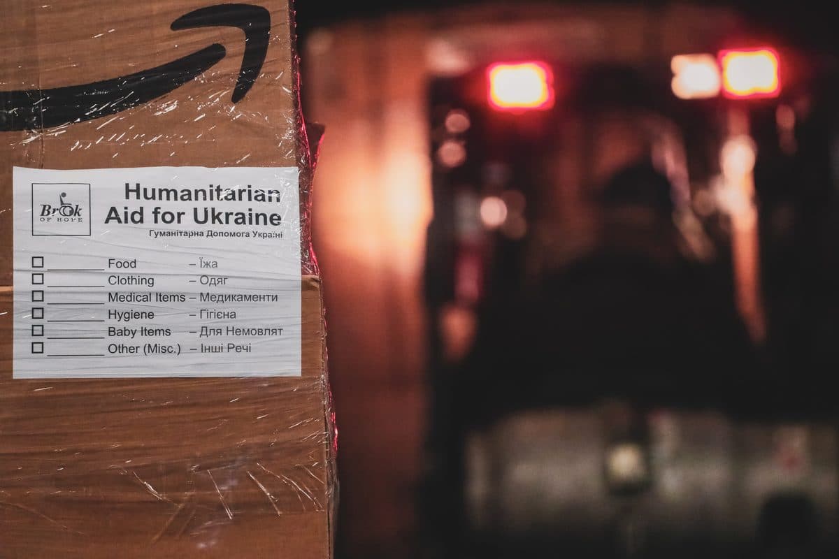 Close-up of Humanitarian Aid for Ukraine labels affixed to shrink-wrapped cardboard aid boxes